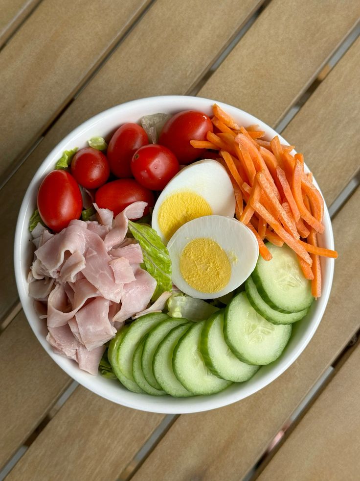 Skål med blandet salat, nødder og fuldkornsbrød som eksempel på varieret hverdagskost